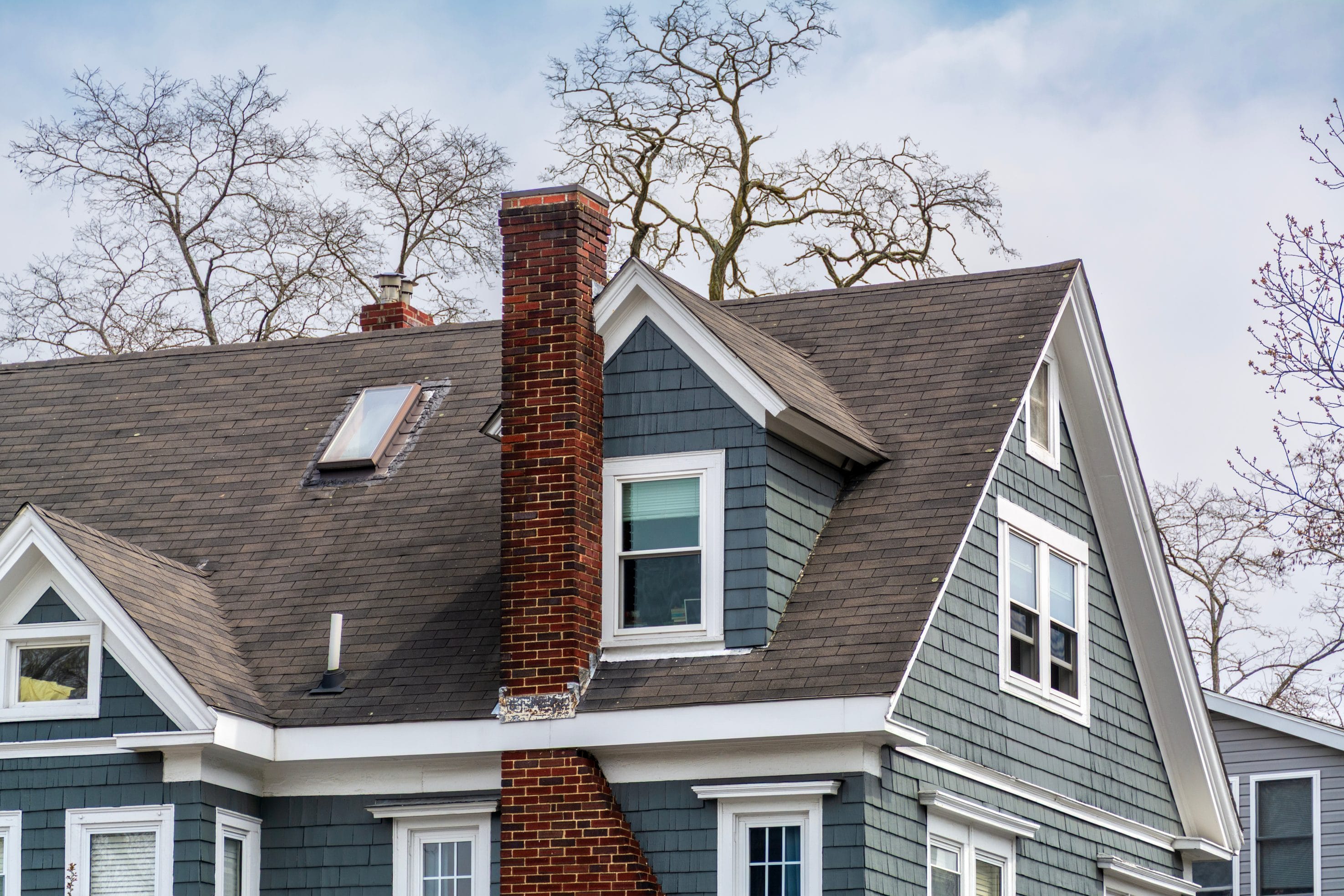 A stock image of a masonry chimney on a blue house.