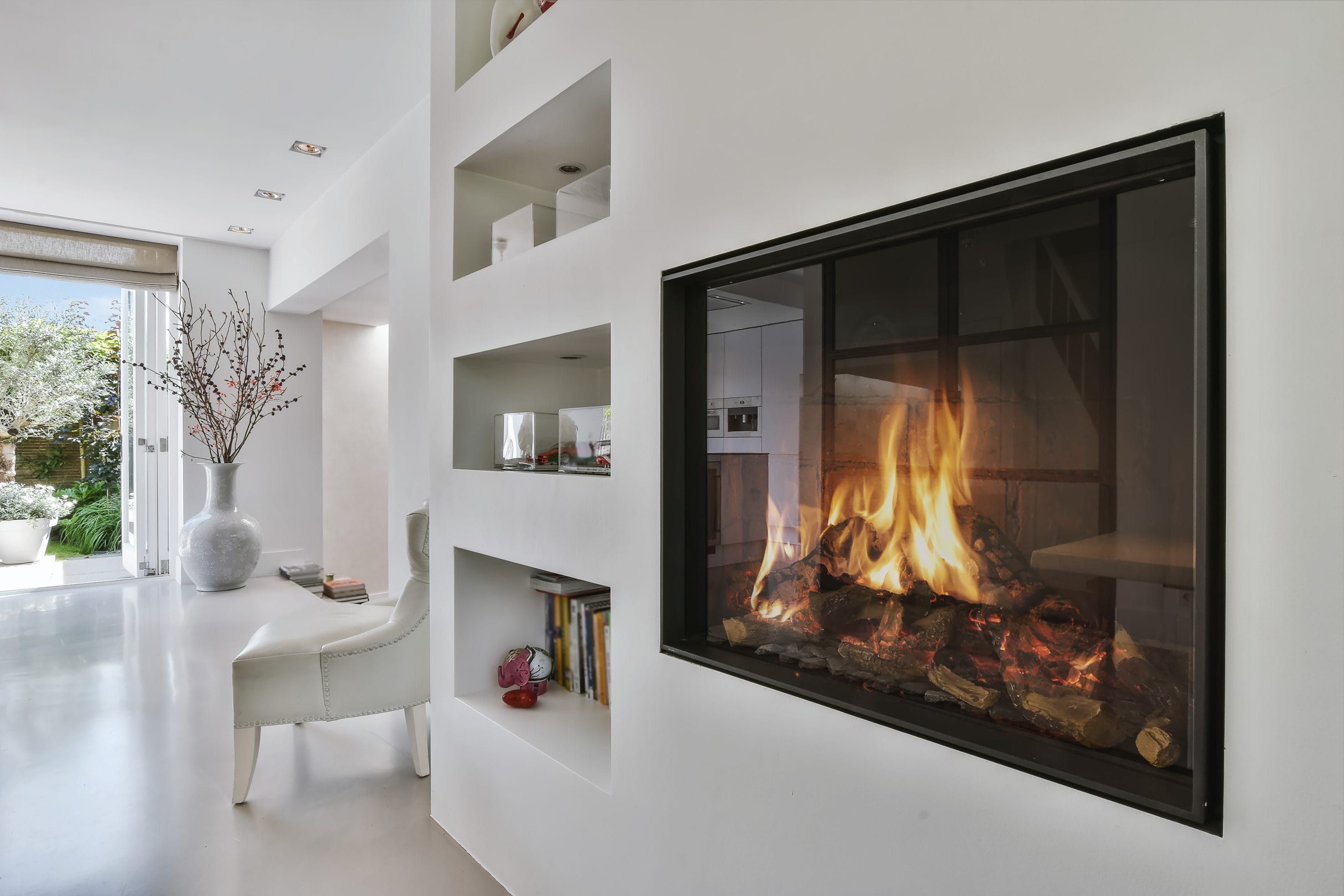 A stock image of a gas fireplace installed into a white wall.