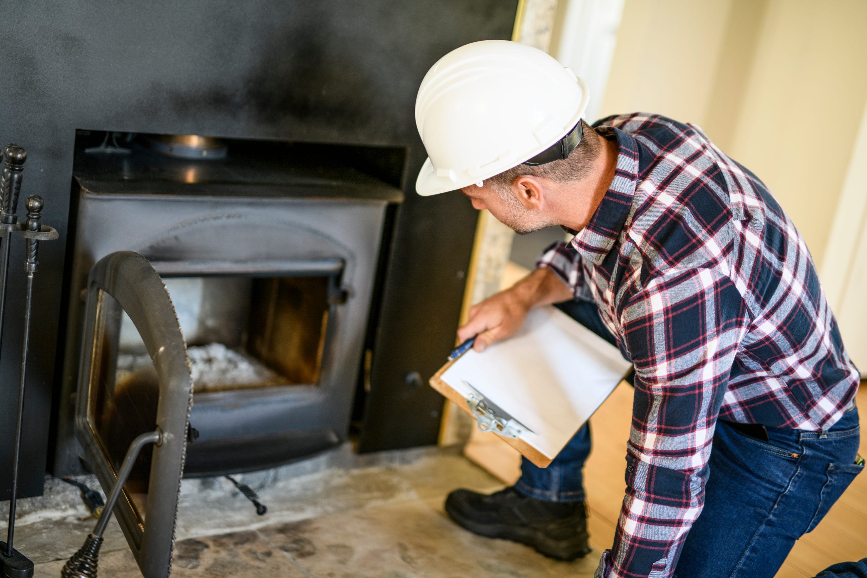 A stock image of a chimney and fireplace inspection taking place.