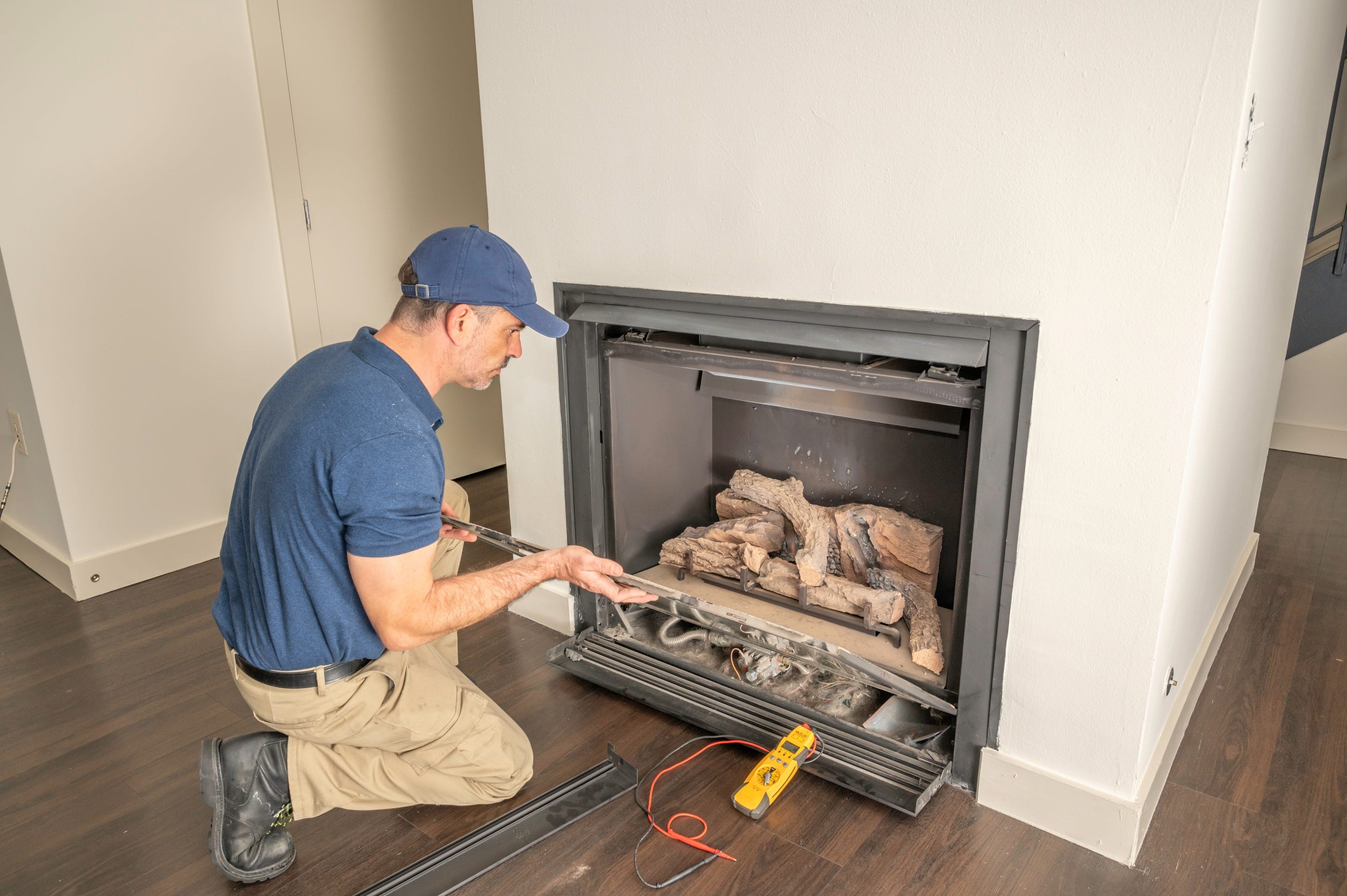 Stock image of a tech performing a gas fireplace service.